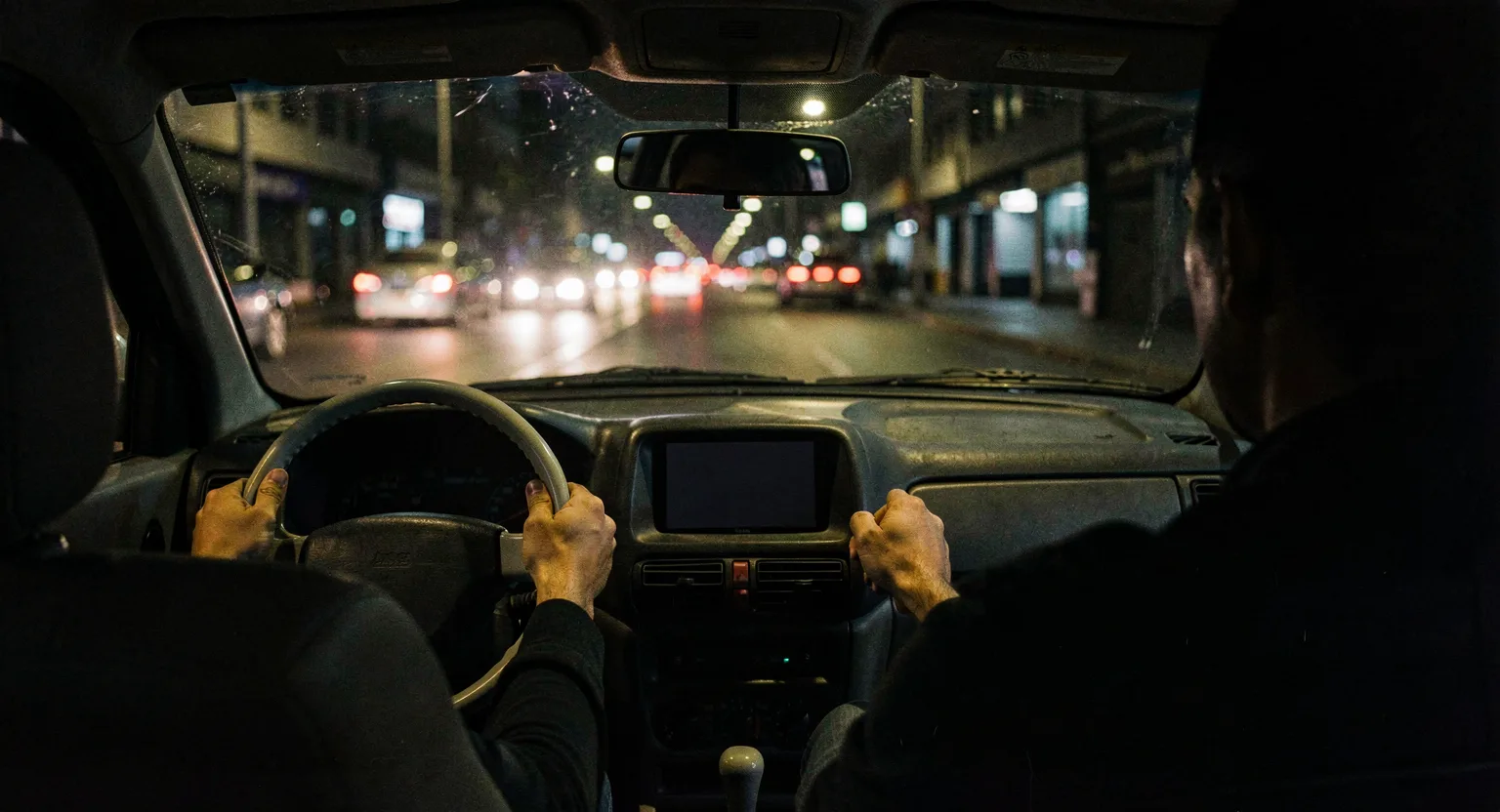 Widok zza kierowcy jadącego nocą przez miasto